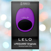 A boxed LELO LIFEGUARD Originals Purple vibrating couples’ ring with "REMOTE CONTROLLED" at the top, set against a blurred background of pastel lights.